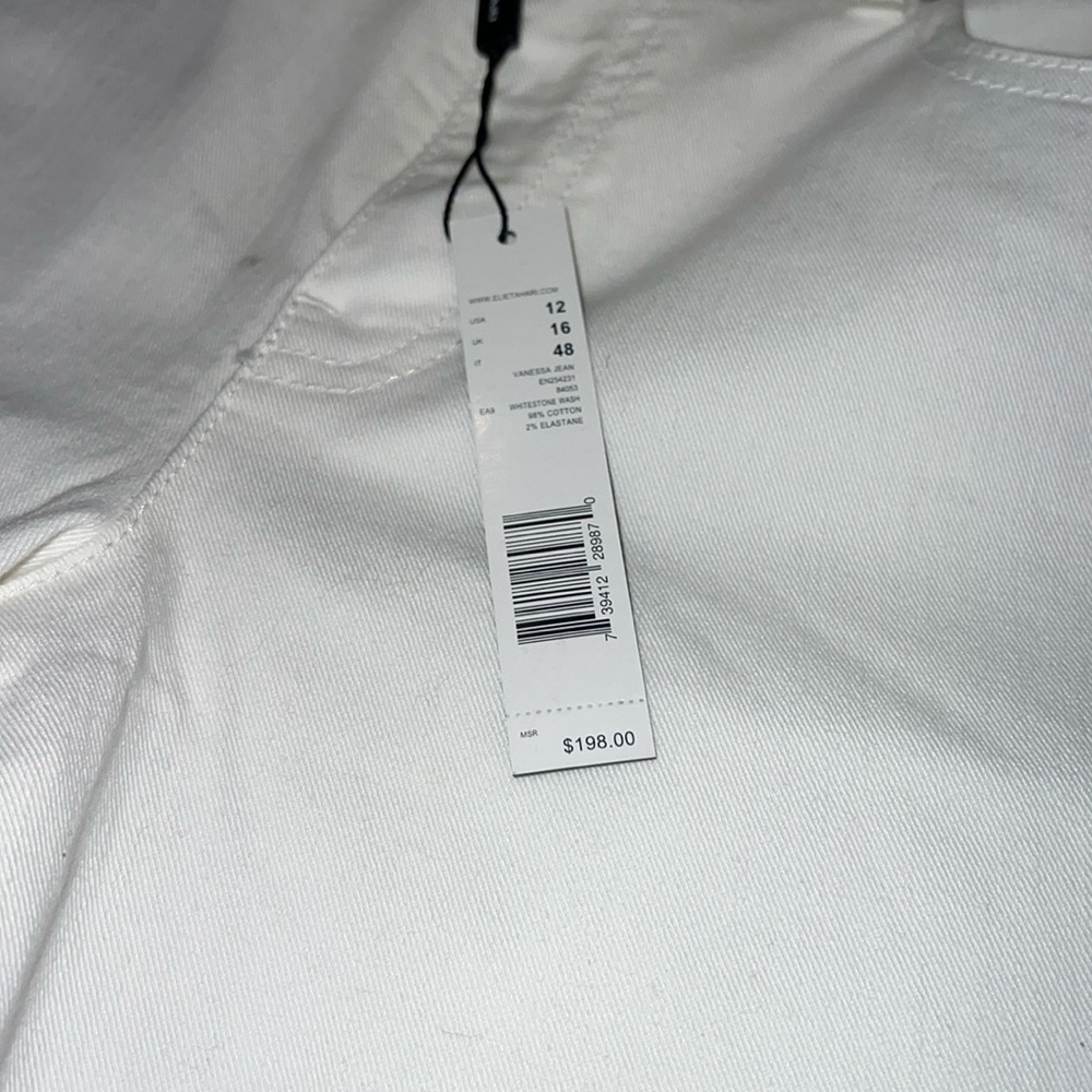 White jeans with a slight flair at the bottom. Regular button and zipper.